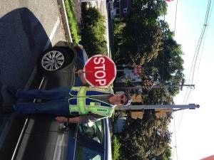 Traffic officer holding a stop sign beside a vehicle